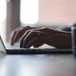 A married man is typing something on his Apple computer.